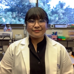 a young woman smiling in a lab 