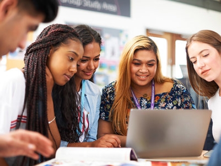 Four female students looking at a laptop - Join Study